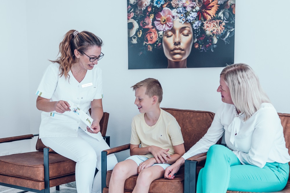 Familienzahnarzt-in der Zahnarztpraxis Dr. Marković mit dem Patienten, dem Jungen und der Mutter